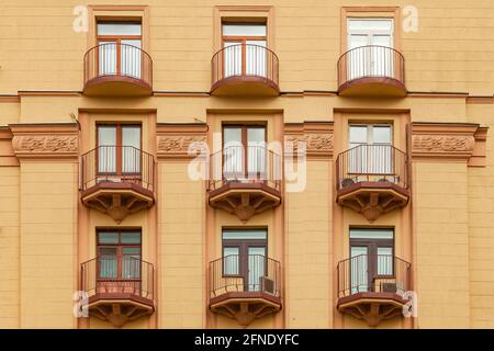 Fragment der Fassade eines modernen Gebäudes mit Metallbalkonen und einem geometrischen Muster. Stockfoto