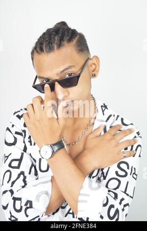 Porträt eines hübschen indischen Mannes in einem modischen Hemd Er überquerte seine Arme und berührte eine Sonnenbrille Stockfoto