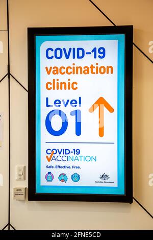 Neonschild, das Menschen zu einer Impfklinik für Covid-19 in Perth, Westaustralien, führt Stockfoto