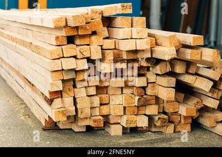 Holzbalken liegen auf dem Boden in einer Tischlerei oder einem Sägewerk. Hintergrund für einen Hersteller von Baustoffen aus Holz. Stockfoto