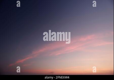 Eine einsame Abenddämmerung bei Sonnenuntergang vor einer langen Wolkenkulisse. Stockfoto