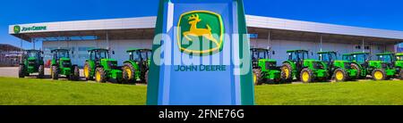 Kiew, Ukraine - 24. August 2020: Die leistungsstarken Traktoren im John Deer-Geschäft in Kiew, Ukraine, am 16. Juni 2020. Reihe brandneuer John Deere-Traktoren vor dem Laden des örtlichen Konsortiums, Ausstellung der neuesten landwirtschaftlichen Maschinen. Stockfoto