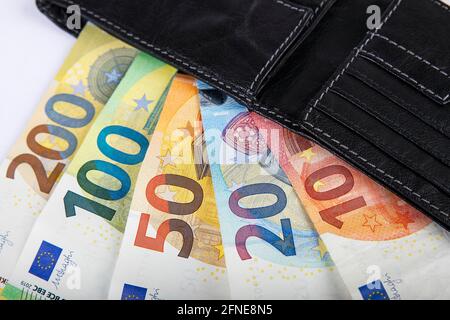 Verschiedene Euro-Banknoten in schwarzer Ledertasche Stockfoto