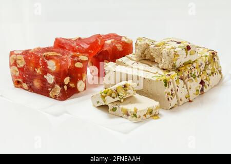 Fruchtbonbons mit Nüssen und Halva mit Pistazien auf weißem Hintergrund. Traditionelle süsse aus dem Nahen Osten. Stockfoto