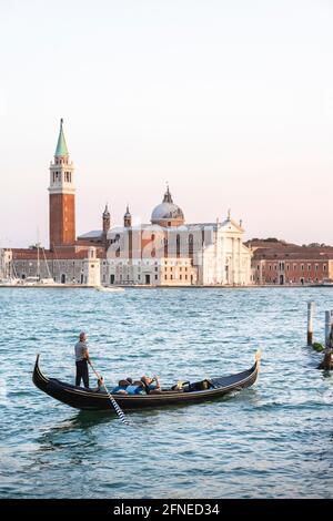 Gondoliere rudert in venezianischer Gondel am Meer, Blick auf die Kirche San Giorgio Maggiore, Venedig, Venetien, Italien Stockfoto