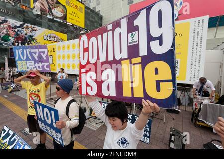 Tokio, Japan. Mai 2021. Demonstranten halten Plakate während einer Demonstration gegen COVID-19-Maßnahmen auf dem Hachiko-Platz.EINE kleine Anzahl von Menschen in Japan sind gegen Coronavirus-Sicherheitsmaßnahmen und Impfungen und glauben, dass die Pandemie eine Lüge ist, auch wenn die Infektionsraten steigen. Quelle: Damon Coulter/SOPA Images/ZUMA Wire/Alamy Live News Stockfoto