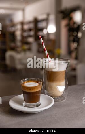 Cappuccino in Lagen und langer Espresso. Warmes Getränk am Morgen, Nahaufnahme. Stockfoto