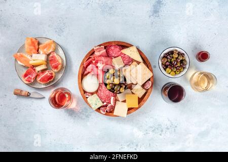 Wurstwaren und Käseplatten, darüber liegende flache Aufnahme mit Kopierfläche. Italienische Antipasti, von oben mit Wein, Oliven und Sandwiches zubereitet Stockfoto