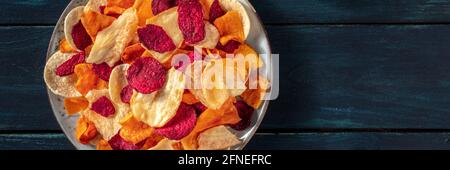Gemüsechips Panorama mit Kopierraum. Rote Bete, Süßkartoffeln und andere Chips, ein gesunder veganer Snack Stockfoto