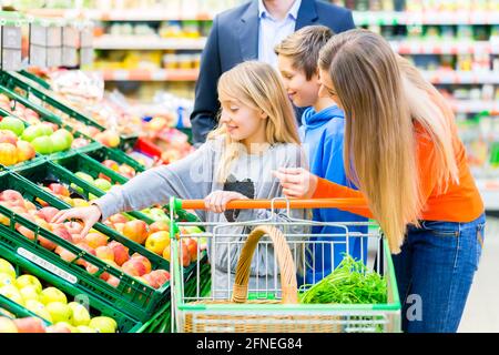 Familie im Supermarkt, die Auswahl der Früchte beim Lebensmitteleinkauf Stockfoto