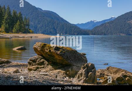 Wunderschöne Landschaft des Harrisonsees mit großen Felsen im Vordergrund und Bergen im Hintergrund.Kanada, BC. Reisefoto, selektiver Fokus, Stockfoto