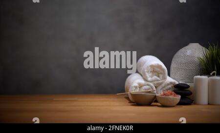 Spa-Tisch mit Massagestein und Handtüchern auf Holztisch Schönheitsbehandlungen und Wellness-Hintergrund Stockfoto