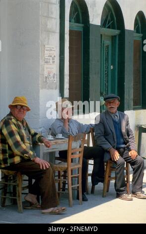 Drei alte Männer ruhten im Schatten eines Cafés auf der Insel Andros. [Automatisierte Übersetzung] Stockfoto