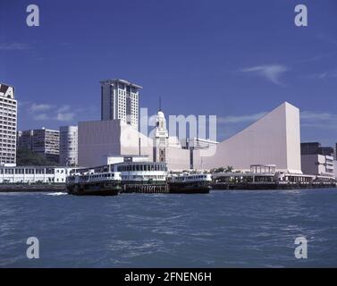 Blick auf Hong Kongs Stadtteil Kowloon mit dem Peninsula Hotel (l.), dem Uhrenturm (m.) und dem Tsim Sha Tsui Cultural Center (r.). Davor die Anlegestelle der Fähren der Star-Ferry Line. [Automatisierte Übersetzung] Stockfoto