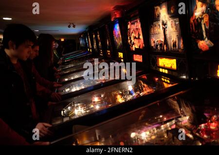 Junge Männer spielen auf Flipper-Maschinen in einer Spielhalle in Ottawa, Ontario, Kanada Stockfoto