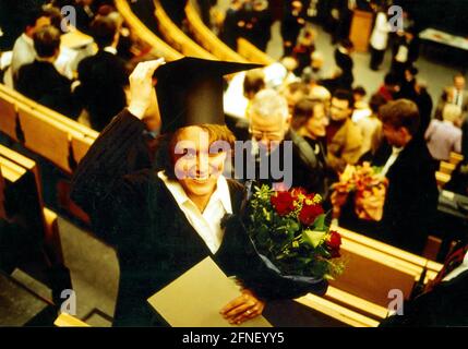 Ein Medizinstudent mit Doktorhut und Blumenstrauß nach einer Abschlussfeier der Medizinischen Fakultät im Auditorium Maximum Clinic der Universität Essen. [Automatisierte Übersetzung] Stockfoto