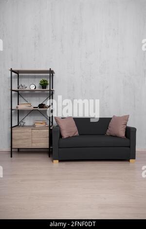 Regal und Sofa mit Kopierraum über Betonwand Hintergrund Stockfoto