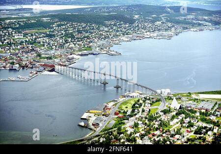 Blick vom Berg Storsteinen nach Tromsö. Die Tromsöbrua-Brücke führt über den Tromsösund und verbindet die Insel Tromsöya, auf der sich das Stadtzentrum befindet, mit dem Festland. Rechts im Vordergrund sieht man den Vorort Tromsdalen mit der modernen Eismeerkathedrale. [Automatisierte Übersetzung] Stockfoto