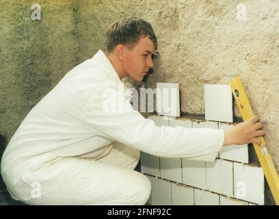 Lehrling im überbetrieblichen Ausbildungszentrum der Bauindustrie in Wriezen beim Fliesenlegen. [Automatisierte Übersetzung] Stockfoto