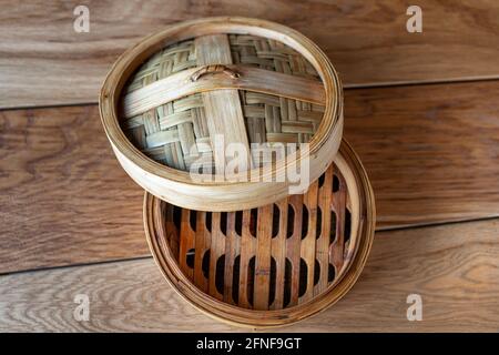 Bambus-Dampfgarer-Set, chinesisches Geschirr auf Holztisch, Draufsicht. Leerer traditioneller asiatischer Bambusdampfer für gedünstete Knödel Dim Sums. Draufsicht. Stockfoto