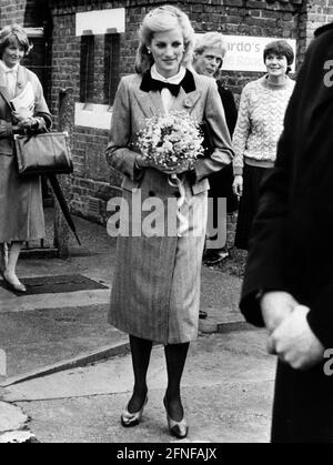 Diana, Prinzessin von Wales und Ehefrau von Prinz Charles, hält einen Blumenstrauß bei einem Besuch in einem Waisenhaus in London. [Automatisierte Übersetzung] Stockfoto