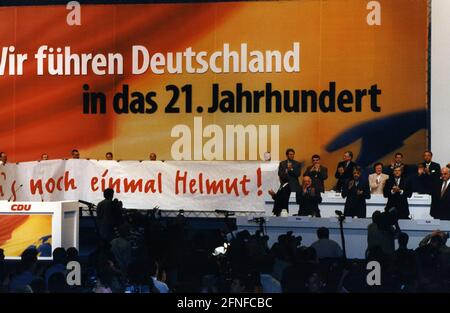 'Blick auf das Podium auf der CDU-Bundesparteikonferenz in Bremen. Delegierte halten ein Banner hoch, auf dem steht: 'Mach es wieder, Helmut!' Neben dem Banner 2. Von links.1. Reihe: Norbert Blüm und ganz rechts Bundeskanzler Helmut Kohl. Im Hintergrund sieht man das Wahlversprechen der CDU: ''Wir führen Deutschland ins 21. Jahrhundert''. [Automatisierte Übersetzung]' Stockfoto