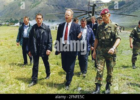 Das Foto zeigt Bundesverteidigungsminister Rudolf Scharping bei einem Besuch im Lager Quatrum für Vertriebene. Diese Bundeswehr ist am Bau dieses Lagers beteiligt. Der Grund für die Flucht war der Kosovo-Konflikt, der vom 28.2.1998. Bis 10.6. 1999 andauerte. In diesem bewaffneten Konflikt ging es um die Kontrolle des Kosovo, unter den verschiedenen Parteien waren die Befreiungsarmee des Kosovo, die jugoslawische Armee, serbische Ordnungskräfte sowie NATO-Truppen unter der Führung der USA. Kosovo war früher eine Provinz Serbiens mit einer Mehrheit der albanischen Bevölkerung innerhalb Jugoslawiens. [Automatisiert Stockfoto