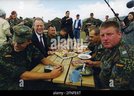 Dieses Foto zeigt Bundesverteidigungsminister Rudolf Scharping bei einem Besuch im Lager Quatrum für Vertriebene. Die deutschen Streitkräfte sind am Bau dieses Lagers beteiligt. Der Grund für die Flucht war der Kosovo-Konflikt, der vom 28.2.1998. Bis 10.6. 1999 andauerte. Bei diesem bewaffneten Konflikt ging es um die Kontrolle des Kosovo. Zu den einzelnen Parteien gehörten die Kosovo-Befreiungsarmee, die jugoslawische Armee, serbische Ordnungskräfte sowie NATO-Truppen unter der Führung der USA. Kosovo war früher eine Provinz Serbiens mit einer Mehrheit der albanischen Bevölkerung innerhalb Jugoslawiens. Stockfoto