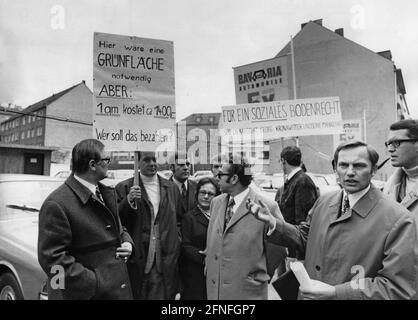 "Der Bürgermeisterkandidat Georg Kronawitter (rechts) bei einer Demonstration gegen den Anstieg der Landpreise in Schabing. Die Demonstranten halten Schilder mit den Inschriften ''EINE Grünfläche wäre hier notwendig. Aber: 1 qm kostet 1400,-. Wer sollte dafür bezahlen'' und ''für ein soziales Landgesetz. SPD-ob-Kandidat Georg Kronawitter“. Undatierte Aufnahme, ca. 1970. [Automatisierte Übersetzung]' Stockfoto