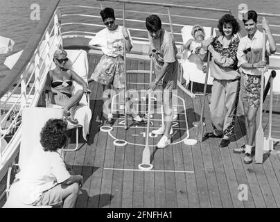 „Passagiere spielen Shuffleboard auf dem Deck der ''MS Europa''. Andere Passagiere sonnen sich auf Liegestühlen. [Automatisierte Übersetzung]' Stockfoto