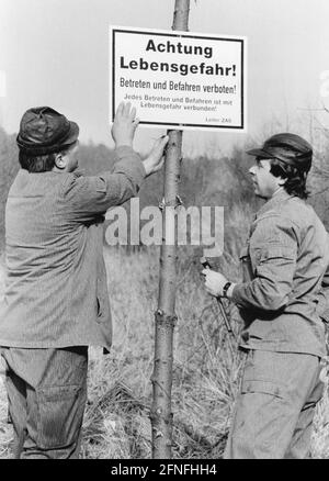 'Zwei Männer halten an der ehemaligen innerdeutschen Grenze ein Schild mit der Aufschrift 'Achtung Lebensgefahr' an einem Holzmast. Direktor: ZAS. Undatierte Fotografie. [Automatisierte Übersetzung]' Stockfoto