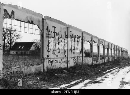 Blick auf den Mauerschutt in Zicherie bei Gifhorn, der als Denkmal für die Teilung des Dorfes steht. Einzelne Notizen oder Symbole sind mit Graffiti auf die ehemalige Grenzmauer geschrieben, darunter die freiwillige Feuerwehr und musikalische Notizen. [Automatisierte Übersetzung] Stockfoto