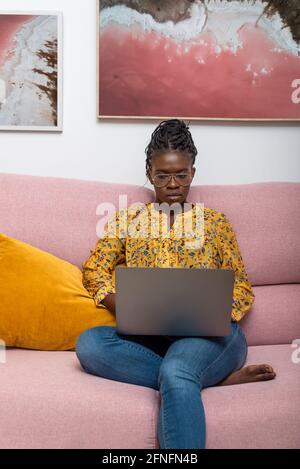 Konzentrierte schwarze Bussineswoman Freiberuflerin arbeitet an Startup-Projekt und sitzen Auf der Couch im Wohnzimmer Stockfoto
