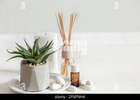 Nahaufnahme eines Duftstabs für einen Raumgeruch und eines Krug mit aromatischem Öl. Stockfoto