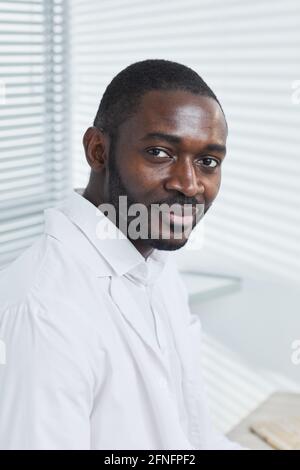Porträt eines jungen afrikanischen Arztes im weißen Mantel beim Betraten Kamera im Krankenhaus Stockfoto