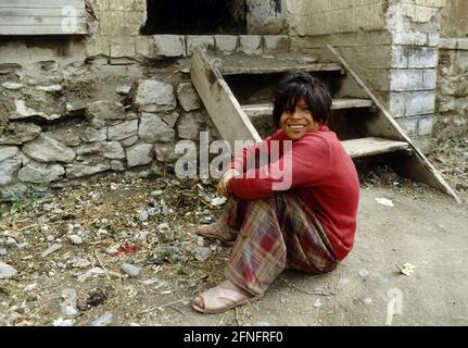 AFG, AFGHANISTAN: EINE geistig behinderte Frau vor ihrem Haus im Bezirk Marastoon von Kabul, Juli 1993 Stockfoto