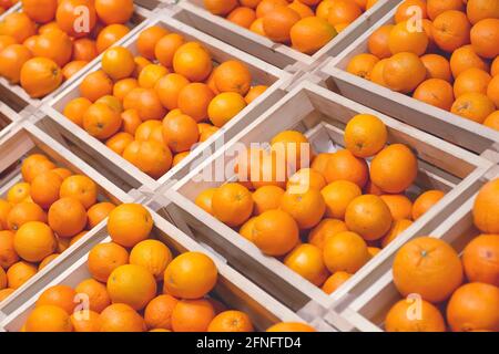 Orangen auf dem Hintergrundmarkt. Frische Orangen für Saft in Holzkisten auf der Theke im Obst- und Gemüsemarkt. Hochwertige Fotos Stockfoto