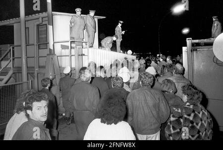 Berlin / Mitte / DDR / Vereinigung / Mauerfall / 1989 die Mauer bricht. Grenzübergang Invalidenstraße in der Nacht vom 9. Auf den 10. November 1989. Ostberliner gehen ohne Pass in West-Berlin, die Mauer ist weg. Zwei DDR-Grenzposten stehen auf der Wache. // Vereinigung / Mauerfall / Geschichte / Kommunismus / DDR-Mauer / Vereinigung [automatisierte Übersetzung] Stockfoto