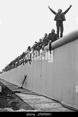 Berlin-City / Mitte / DDR / Berliner Mauer 12.11.1989 Potsdamer Platz. Die Mauer wird von DDR-Grenzsoldaten einer Stasi-Einheit abgerissen. Die Berliner sind auf die Mauer geklettert, um eine bessere Aussicht zu bekommen. // Vereinigung / Volksarmee / DDR-Grenzposten / Geschichte / Kommunismus / Tiergarten Stockfoto