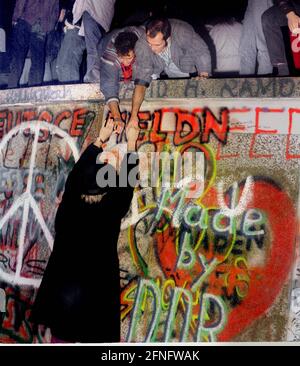 Berlin / DDR / Pariser Platz / 1989 die Berliner Mauer ist gefallen, Nacht vom 9. November auf den 10. November 1989, 11 Uhr. Berliner kletterten die Mauer am Brandenburger Tor. Die DDR-Grenzposten tun nichts. Die DDR geht in dieser Nacht zu Ende // Vereinigung / Tiergarten Geschichte / Kommunismus Stockfoto