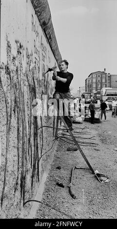 Berliner Bezirke / Kreuzberg / 1990 die Mauer ist offen. Überall schneiden Wandpecker Teile aus der anti-imperialistischen Schutzmauer und verkaufen sie als Souvenirs, 5 D-Mark pro Stück. Hier hacken zwei Polen in der Zimmerstraße. // DDR-Mauer / Ausländer / PL / Geschichte der Mauer / Kommunismus [automatisierte Übersetzung] Stockfoto