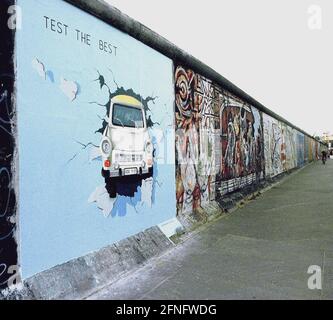 Berlin / DDR / Geschichte / 1991 East Side Gallery. An einem Mauerstück in Friedrichshain, direkt an der Spree, haben viele Künstler 1990 die antiimperialistische Schutzmauer (auf der ehemaligen Ostseite) gemalt. Sie nannten das Stück der Mauer East Side Gallery. Das Bild zeigt einen Trabi, der durch die Wand bricht, gemalt von Birgits Kinder. // Wand / Kunst / Trabi / Vereinigung / Bezirke / Friedrichshain Geschichte / Kommunismus / Vereinigung [automatisierte Übersetzung] Stockfoto