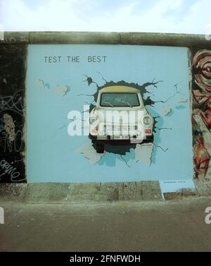 Berlin / DDR / Geschichte / 1991 East Side Gallery. An einem Mauerstück in Friedrichshain, direkt an der Spree, haben 1990 viele Künstler die antiimperialistische Schutzmauer (auf der ehemaligen Ostseite) gemalt. Sie nannten das Stück der Mauer East Side Gallery. Das Bild zeigt einen Trabi, der durch die Wand bricht, gemalt von Birgits Kinder. // Wand / Kunst / Trabi / Vereinigung / Bezirke / Friedrichshain Geschichte / Kommunismus / Vereinigung [automatisierte Übersetzung] Stockfoto