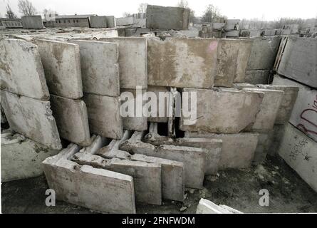 Berlin-Bezirk / DDR / Berliner Mauer 3 / 1991 Treptow: Überall in der Stadt wird die Mauer abgerissen, die Betonelemente werden irgendwo gelagert, hier am Stadtrand von Groß-Glienicke. Bunt bemalte Stücke werden an Sammler verkauft, aber die meisten von ihnen werden zu Baumaterial geschreddert. Symbol für das Ende der DDR, das Ende der antifaschistischen Mauer. // Sozialismus / Wiedervereinigung / Geschichte / Kommunismus [automatisierte Übersetzung] Stockfoto