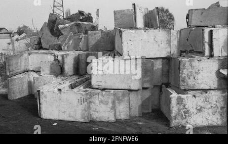 Berlin-Bezirk / DDR / Berliner Mauer 3 / 1991 Treptow: Überall in der Stadt wird die Mauer abgerissen, die Betonelemente werden irgendwo gelagert, hier am Stadtrand von Groß-Glienicke. Bunt bemalte Stücke werden an Sammler verkauft, aber die meisten von ihnen werden zu Baumaterial geschreddert. Symbol für das Ende der DDR, das Ende der antifaschistischen Mauer. // Sozialismus / Wiedervereinigung / Geschichte / Kommunismus [automatisierte Übersetzung] Stockfoto