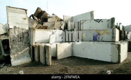 Berlin-Bezirk / DDR / Berliner Mauer 3 / 1991 Treptow: Überall in der Stadt wird die Mauer abgerissen, die Betonelemente werden irgendwo gelagert, hier am Stadtrand von Groß-Glienicke. Bunt bemalte Stücke werden an Sammler verkauft, aber die meisten von ihnen werden zu Baumaterial geschreddert. Symbol für das Ende der DDR, das Ende der antifaschistischen Mauer. // Sozialismus / Wiedervereinigung / Geschichte / Kommunismus [automatisierte Übersetzung] Stockfoto