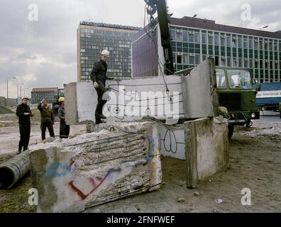 Berlin-Bezirke / DDR / Mauer / 1990 Kreuzberg: DDR-Grenzposten reißen ihre Mauer nieder. Im Hintergrund die Zentrale des Springer-Verlages. Ende der antiimperialistischen Schutzmauer und der DDR. // Grenze / Vereinigung / DDR / Bezirke / Geschichte / Kommunismus [automatisierte Übersetzung] Stockfoto