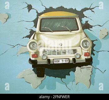 Berlin / DDR / Geschichte / 1991 East Side Gallery. An einem Mauerstück in Friedrichshain, direkt an der Spree, haben 1990 viele Künstler die antiimperialistische Schutzmauer (auf der ehemaligen Ostseite) gemalt. Sie nannten das Stück der Mauer East Side Gallery. Das Bild zeigt einen Trabi, der durch die Wand bricht, gemalt von Birgits Kinder. // Wand / Kunst / Trabi / Vereinigung / Bezirke / Friedrichshain Geschichte / Kommunismus / Vereinigung [automatisierte Übersetzung] Stockfoto