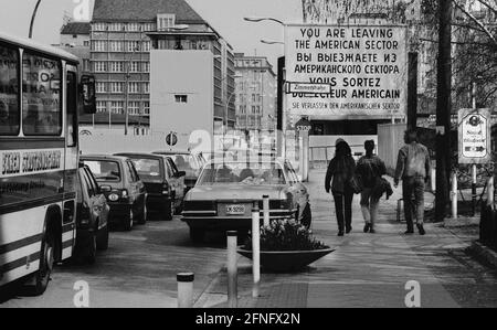 Berlin-Bezirke / DDR-Mauer / 1985 Checkpoint Charly. Der Grenzübergang zwischen Kreuzberg und Mitte ist für Ausländer, darunter Diplomaten, reserviert. Sie werden vom deutschen Zoll, einem Hilfsorgan der Westalliierten, abgeräumt. Zwei Geschäftsleute gehen nach Ost-Berlin. Am Checkpoint Charly standen sich amerikanische und sowjetische Panzer während des Mauerbaus 1961 gegenüber. Viersprachiges Zeichen der 4 Alliierten: Sie verlassen den amerikanischen Sektor // Berliner Status / Checkpoint / Grenze / Bezirke / // Geschichte / Alliierten / Kommunismus / Sowjets [automatisierte Übersetzung] Stockfoto