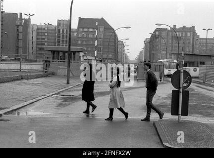 Berlin-Bezirke / DDR-Mauer / 1985 Checkpoint Charly. Der Grenzübergang zwischen Kreuzberg und Mitte ist für Ausländer, darunter Diplomaten, reserviert. Sie werden vom deutschen Zoll, einem Hilfsorgan der Westalliierten, abgeräumt. Zwei Geschäftsleute gehen nach Ost-Berlin. Am Checkpoint Charly standen sich amerikanische und sowjetische Panzer während des Mauerbaus 1961 gegenüber. Viersprachiges Zeichen der 4 Alliierten: Sie verlassen den amerikanischen Sektor // Berliner Status / Checkpoint / Grenze / Bezirke / // Geschichte / Alliierten / Kommunismus / Sowjets [automatisierte Übersetzung] Stockfoto